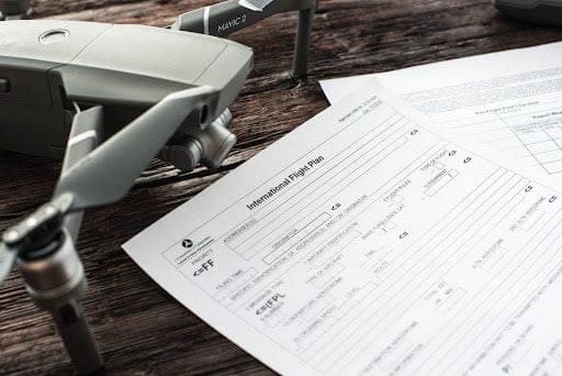 A drone and some papers on a table.